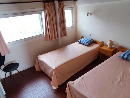 une chambre avec deux lits et une fenêtre dans l'établissement Appartement 2 chambres avec terrasse au Lavandou - FR-1-308-122, au Lavandou
