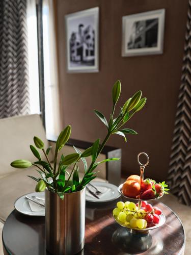 a table with plates of fruit and a potted plant at Hôtel particulier Le DOGE - Relais & Châteaux in Casablanca