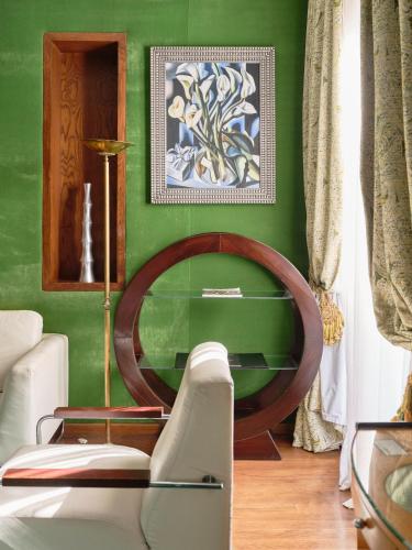 a green living room with a chair and a table at Hôtel particulier Le DOGE - Relais & Châteaux in Casablanca