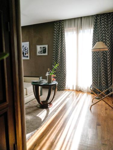 a living room with a table and a large window at Hôtel particulier Le DOGE - Relais & Châteaux in Casablanca