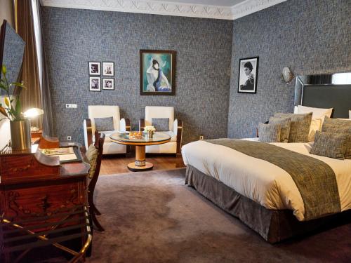 a bedroom with a bed and a table and chairs at Hôtel particulier Le DOGE - Relais & Châteaux in Casablanca