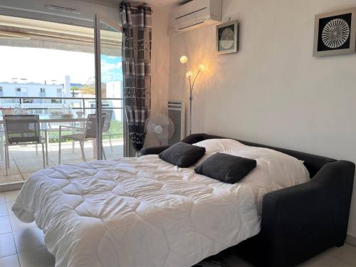 sypialnia z dużym łóżkiem z 2 poduszkami w obiekcie Charmant T2 climatisé avec grande terrasse, piscine et parking privatif, proche plage et commerces. - FR-1-251-441 w mieście Le Lavandou