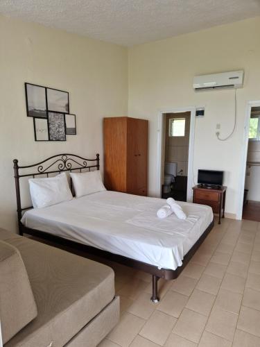 a bedroom with a bed and a couch at On the wave studios Spitakia sto kyma in Nikiti