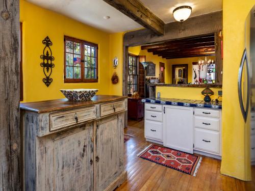 eine Küche mit gelben Wänden und einer Holzinsel in der Unterkunft La Vida Buena, 2 Bedrooms, Sleeps 4, Fireplace, Patio, Yard, Grill in Santa Fe