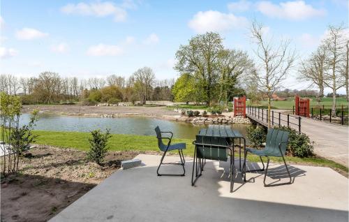 a table and chairs sitting next to a lake at Stunning Apartment In Humble With Wifi in Humble