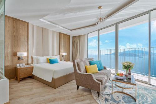 ein Hotelzimmer mit einem Bett, einem Stuhl und Fenstern in der Unterkunft OceanDream Panorama Luxury Suites in Nha Trang