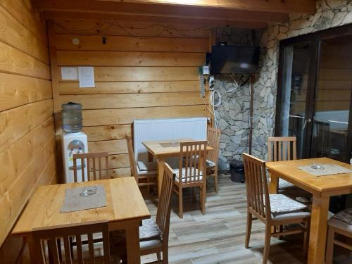 a dining room with wooden tables and chairs at Vila Kula in Crni Vrh