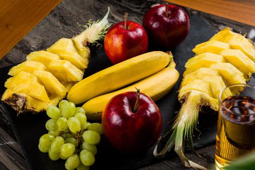a table with apples bananas grapes and other fruit at Amazonia Hotel in Timişoara