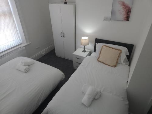 1 dormitorio con 2 camas y una lámpara en una mesa en Long Stay, Contractors, Stags & Hens, en Elswick