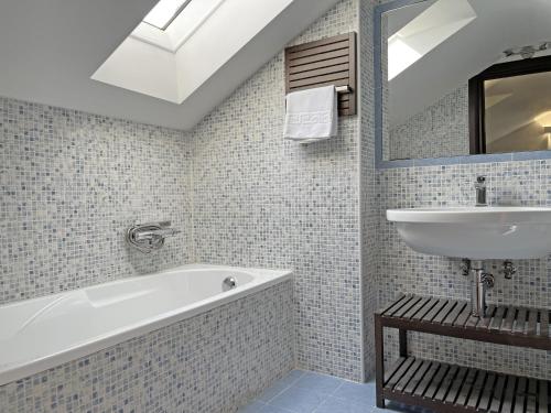 a bathroom with a white tub and a sink at B&B Belvedere in Macerata