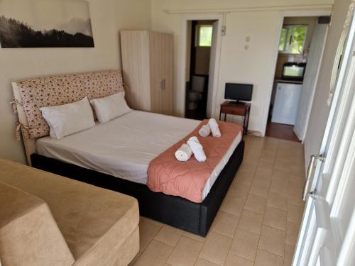 a bedroom with a bed with two towels on it at On the wave studios Spitakia sto kyma in Nikiti