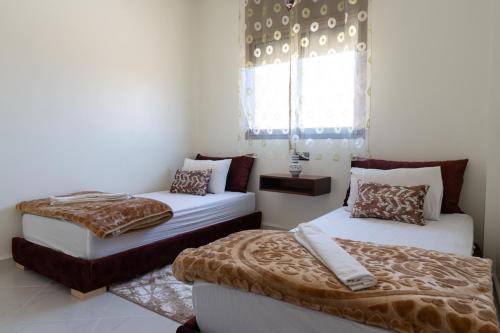 a bedroom with two beds and a window at Imlil apartment climatisé in Azrou