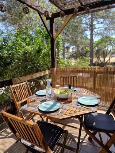 une table et des chaises en bois sur une terrasse dans l'établissement Mini Villa 69 - Piscine chauffée, à Serra-di-Ferro