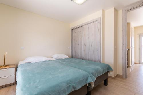 a bedroom with a bed with a blue blanket at Numar S by ALGARVEMANTA in Manta Rota
