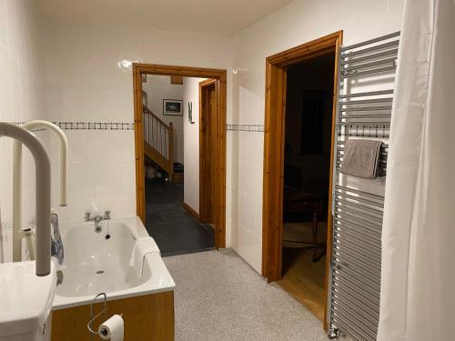 a bathroom with a bath tub and a sink at Pentrego Isaf in Meifod