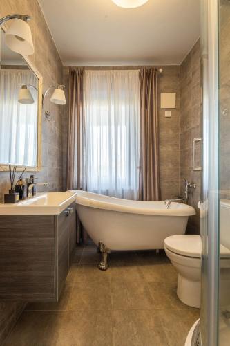 a bathroom with a tub and a toilet and a sink at Forest Cottage in Palanga