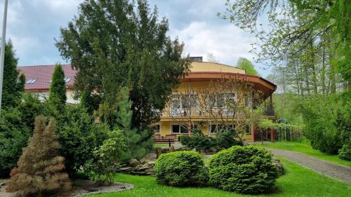 Una casa grande con un jardín enfrente. en Ośrodek SUDETY, en Jarnołtówek