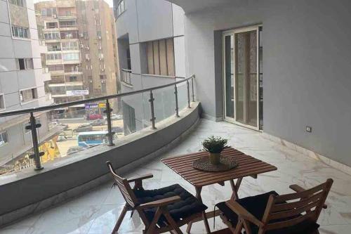 einen Balkon mit einem Tisch und Stühlen auf einem Gebäude in der Unterkunft Jood Residences Apartment in Kairo