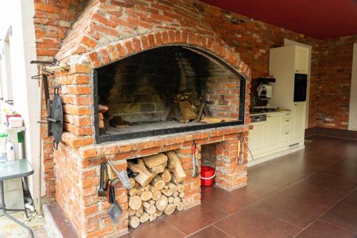 a brick oven with a pile of logs in it at Apartments MoonRiver in Bihać