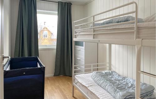 a bedroom with two bunk beds and a window at Awesome Apartment In Rros With 3 Bedrooms in Røros