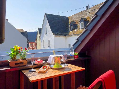 einen Tisch mit Essen und Weingläsern auf dem Balkon in der Unterkunft Ferienhaus-Am-Alten-Stadttor in Ediger-Eller