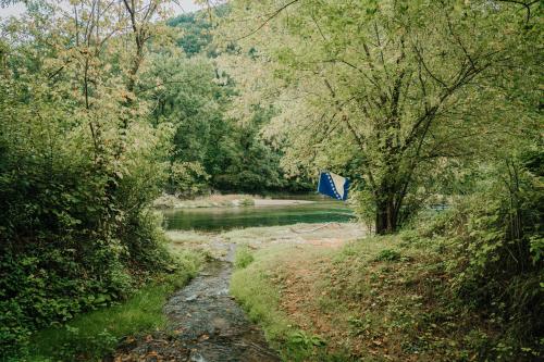 a river with a blue flag in a forest at Apartments MoonRiver in Bihać