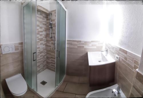 uma casa de banho com um chuveiro, um WC e um lavatório. em VistaMare em Villaputzu