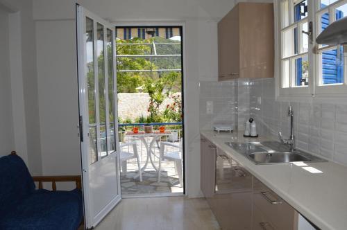 a kitchen with a sink and a view of a patio at Emilios Eleni studios in Nydri