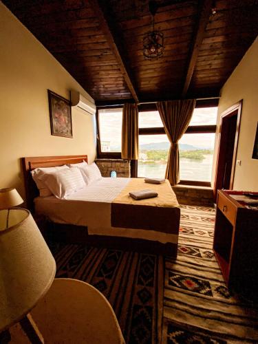 a bedroom with a bed and a large window at Hotel Iliria in Shkodër