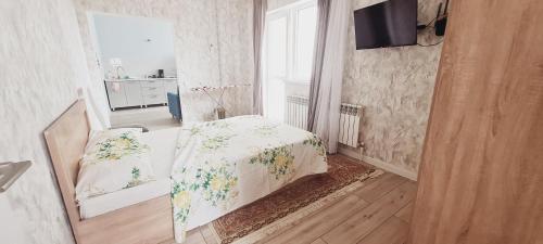 Un dormitorio con una cama con una manta. en ЖК PRESIDENT в 5 мин от моря, en Aktau