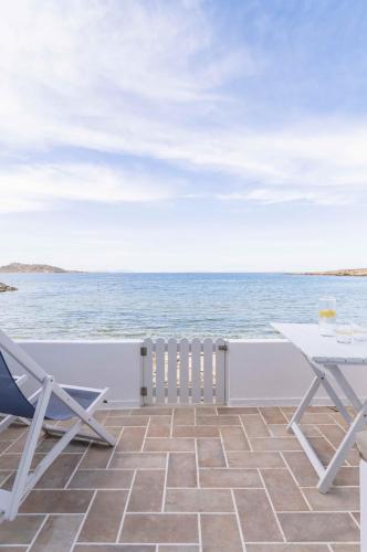 a patio with chairs and the ocean in the background at Afluencia Complex Studio No2 in Naousa
