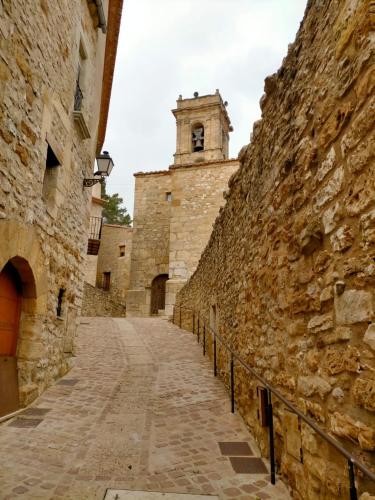 an alley in an old stone building with a clock tower at Albaga in Sant Jordi