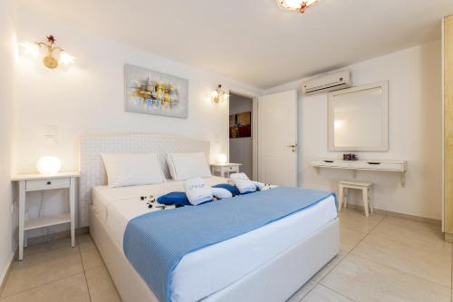 a bedroom with a large white bed with blue sheets at Crystal Villa III in Chrissi Akti