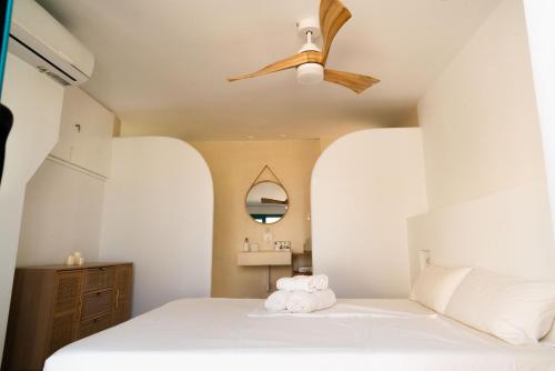 a bedroom with a white bed with a ceiling fan at La Casa Turquesa in Águilas