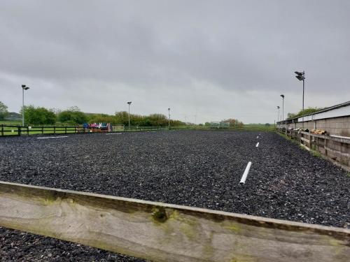 an empty parking lot with a fence and street lights at Braemar Equestrian, East Riding of Yorkshire in Burton Pidsea