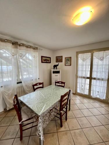 comedor con mesa, sillas y ventanas en La casa di Tamara en Torre del Lago Puccini