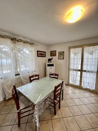 - une salle à manger avec une table, des chaises et des fenêtres dans l'établissement La casa di Tamara, à Torre del Lago Puccini