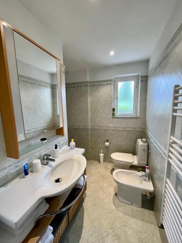 La salle de bains est pourvue de 2 lavabos et de toilettes. dans l'établissement La casa di Tamara, à Torre del Lago Puccini