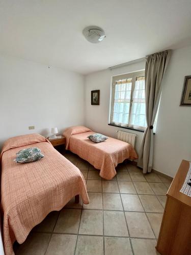 Cette chambre comprend 2 lits et une fenêtre. dans l'établissement La casa di Tamara, à Torre del Lago Puccini