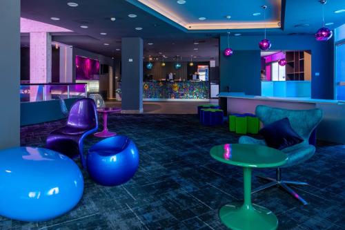 a lobby with purple and blue chairs and a bar at Abraham Eilat in Eilat
