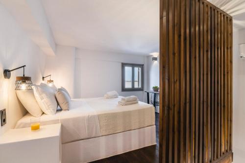 een slaapkamer met een bed en een houten muur bij Afluencia Complex Studio No1 in Naousa