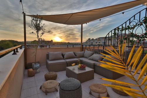 a patio with a couch and a table on a balcony at Messembria Resort in Sunny Beach