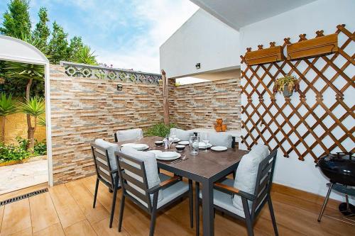 a dining room with a table and chairs and a brick wall at Beautiful and Quiet Family Townhouse in Great Location in Marbella