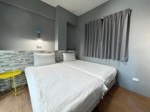 a bedroom with a large bed and a yellow stool at Taitung Sun forest in Taitung City