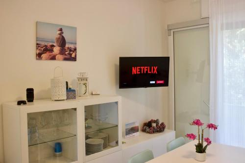 a white cabinet with a tv on a wall at Villa Antonietta 3, tra pineta e mare in Bibione