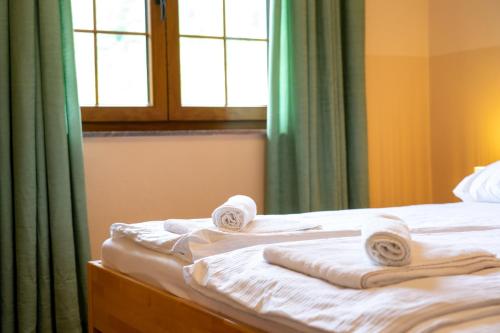 a bed with towels on it with a window at Apartments MoonRiver in Bihać