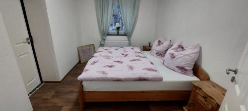 um quarto com uma cama com lençóis e almofadas cor-de-rosa em gramelower see em Teschendorf