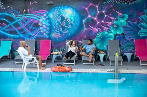 a group of people sitting in chairs next to a swimming pool at Abraham Eilat in Eilat