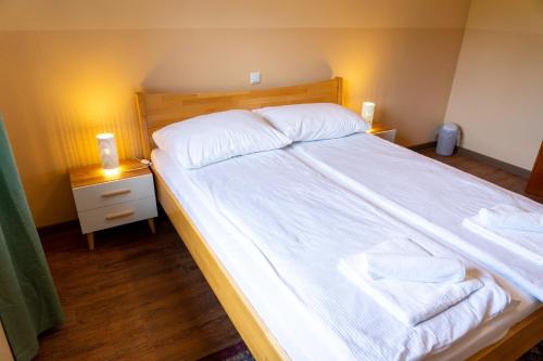 a large bed with white sheets and towels on it at Apartments MoonRiver in Bihać