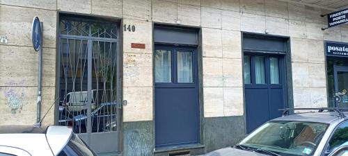 budynek z niebieskimi drzwiami i dwoma oknami w obiekcie BeTurin w Turynie